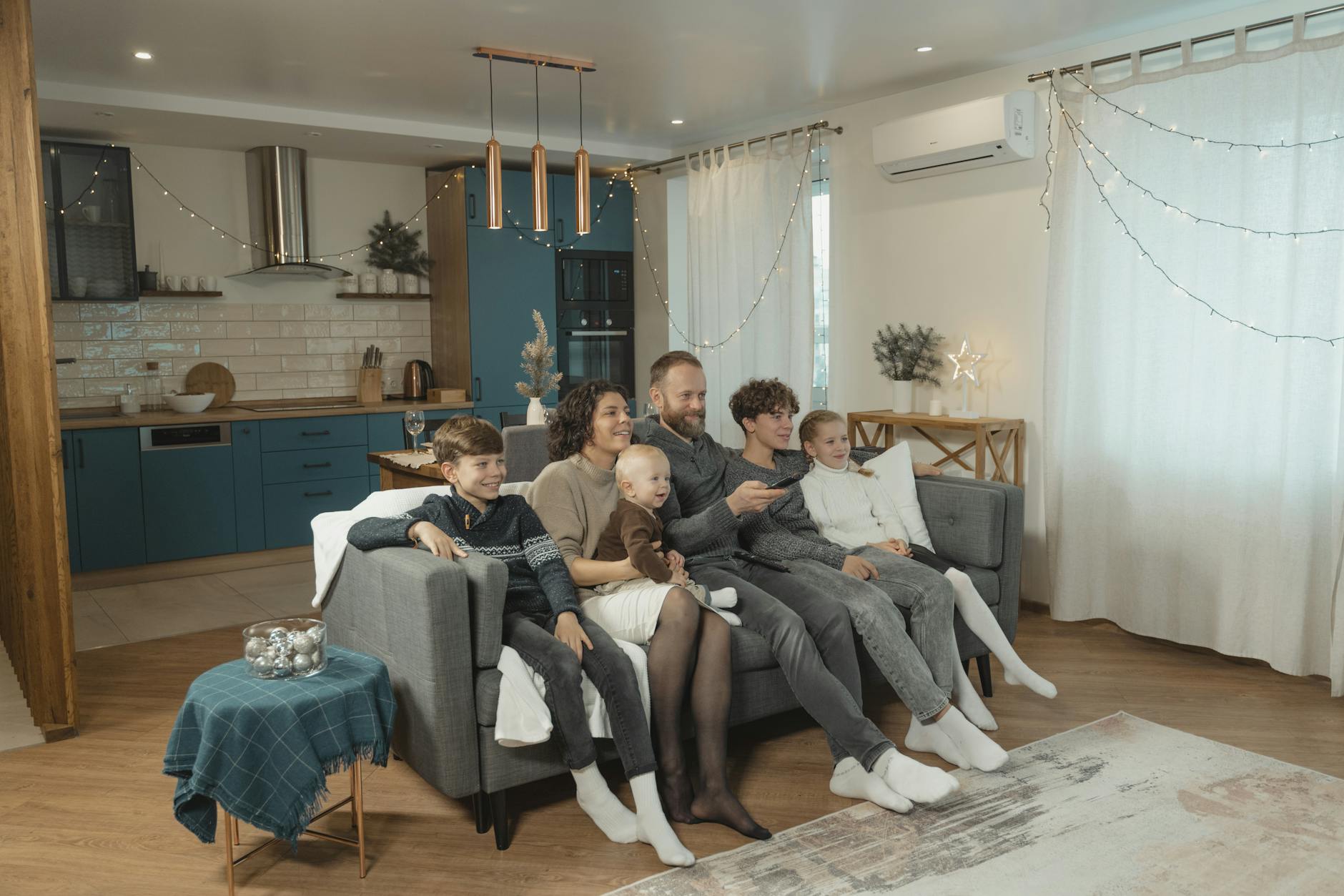 Rodzina wypoczywa na kanapie w ciepłym, przytulnym salonie