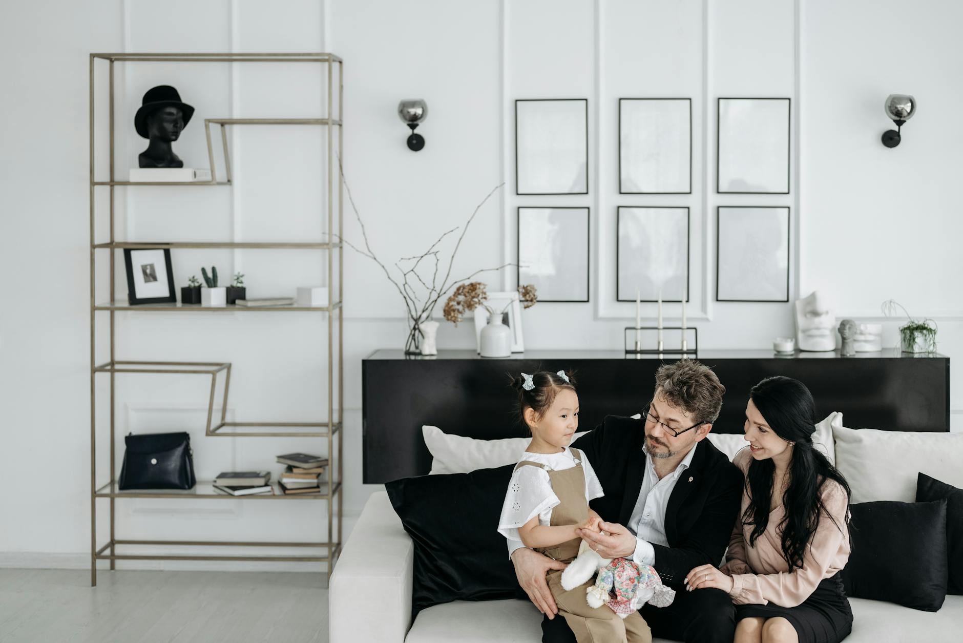 Rodzina z dzieckiem spędza czas w nowoczesnym, ciepłym salonie Rodzina z dzieckiem spędza czas w nowoczesnym, ciepłym salonie