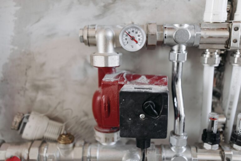 Manometr i stalowe rury w instalacji hydraulicznej